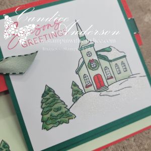 A decorated Christmas card featuring a church with a wreath, surrounded by trees and snow, capturing a festive holiday scene.