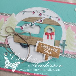 A festive card featuring a decorated camper with lights and a 'Trees For Sale' sign, surrounded by green trees and a pastel background.