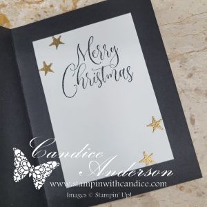 The inside of a black Christmas card featuring the text 'Merry Christmas' in elegant script, accompanied by gold star embellishments.