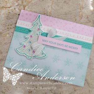 A pastel Christmas card featuring a decorative tree with colorful embellishments and a sentiment that reads 'MAY YOUR DAYS BE MERRY' against a soft background.
