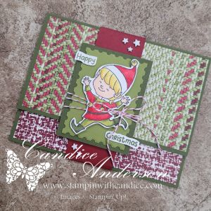 A handmade gift card holder designed for the Christmas season, featuring an elf illustration, festive patterns in red and green, and the greeting 'Happy Christmas.'