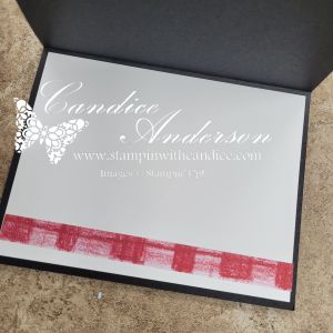 An inside view of a greeting card featuring a simple design with a silver surface and a red checkered border along the bottom.