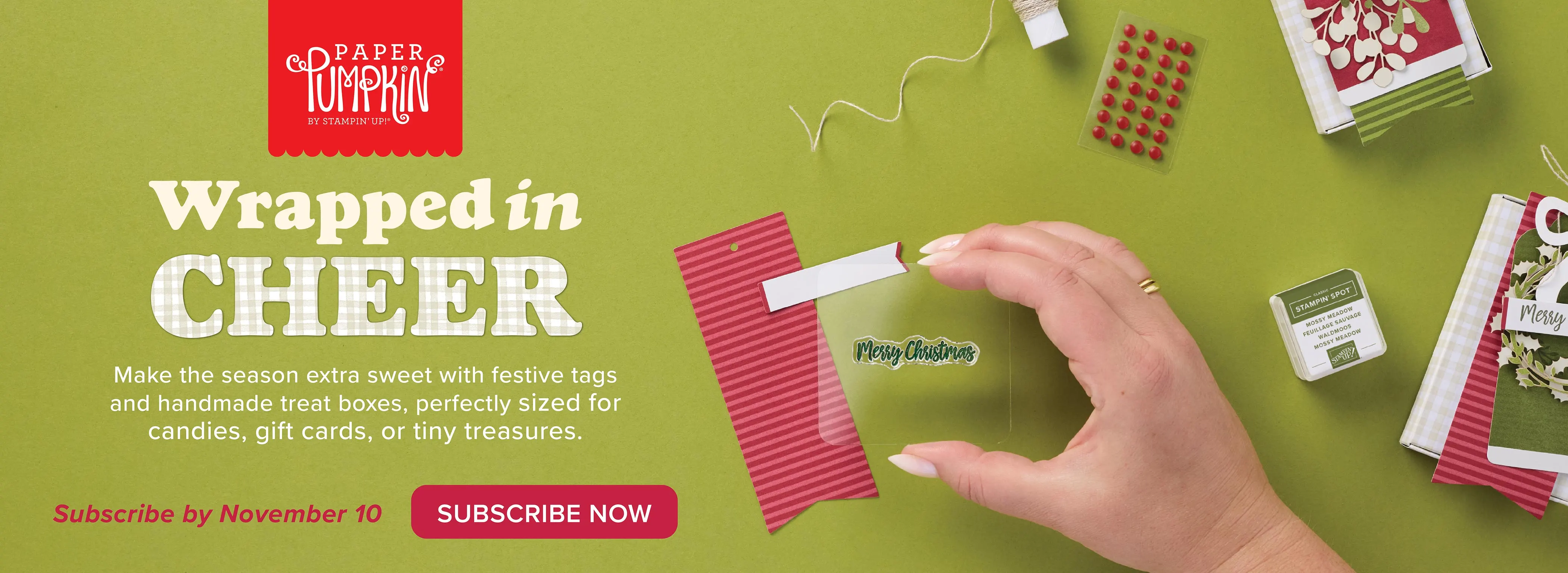 Promotional image for Paper Pumpkin kit featuring festive crafting supplies, including tags, treat boxes, and a Christmas stamp, all set against a green background.