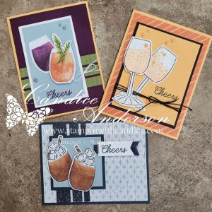 Three handmade greeting cards featuring drinks. The left card showcases a colorful cocktail with a pineapple garnish, the center card displays champagne flutes with bubbles, and the right card features glasses filled with a cold beverage and ice, all with the word 'Cheers'.