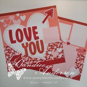 A scrapbook layout featuring a large heart with the text 'LOVE YOU' in bold letters, accompanied by decorative elements such as hearts and an arrow. The color scheme includes various shades of pink and red, with sections for additional photos or notes.