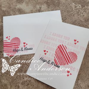 Two handmade greeting cards featuring red striped hearts and the phrase 'Hugs & Kisses'. One card has the text 'I adore you' repeated in the background.