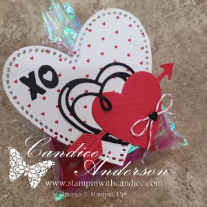 A decorative Valentine's Day card featuring layered hearts, one red with a black outline, and the text 'XO' on a white heart background with small red hearts.