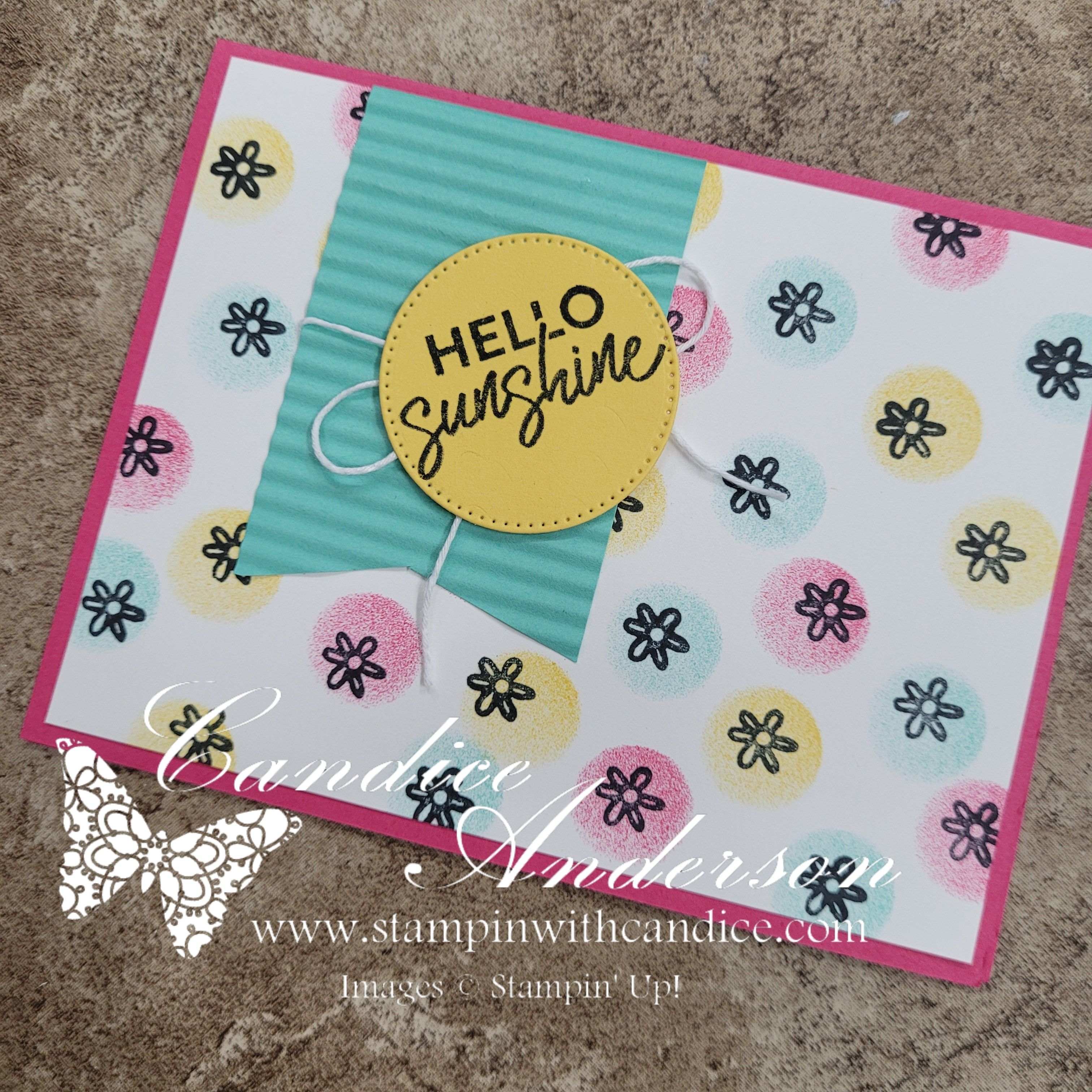 A colorful greeting card featuring a central yellow circle with the text 'HELLO Sunshine', set against a patterned background of pastel circles and small black flowers.