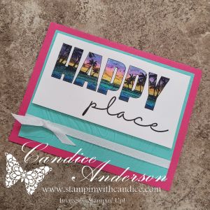 A colorful handmade card featuring the text 'HAPPY place' in a vibrant design with palm trees. The card has a pink border and a light blue ribbon.