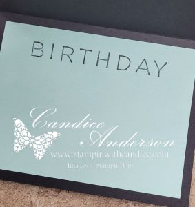 A birthday card with the word 'BIRTHDAY' in bold letters on a light blue background, featuring a white butterfly and the name 'Candice Anderson' along with the website 'www.stampinwithcandice.com' printed below.