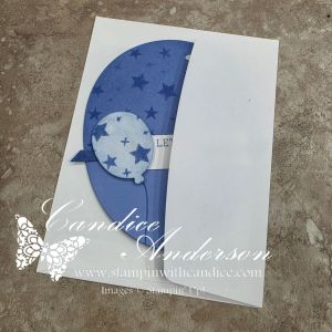 A greeting card featuring a blue balloon design with white stars, partially open to reveal a message inside.